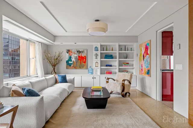 a living room with furniture and a book shelf