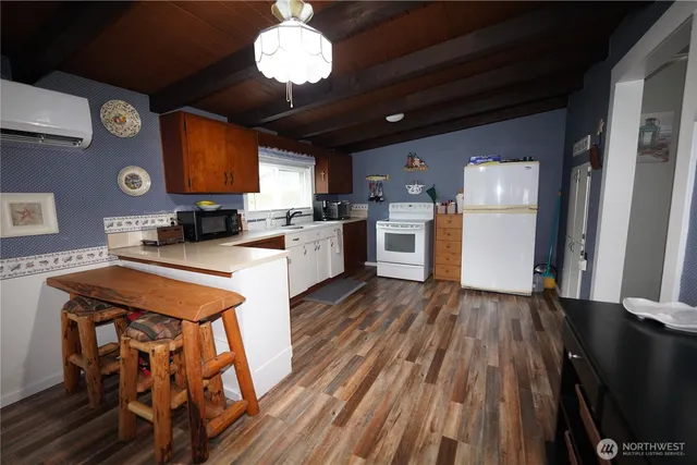 a kitchen with wooden floors and refrigerator