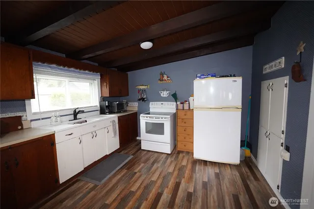 a kitchen with white cabinets and white appliances