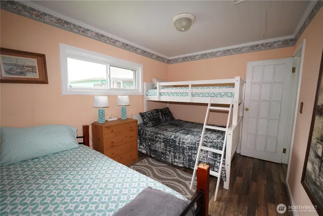 a bedroom with a bed and a dresser next to a window