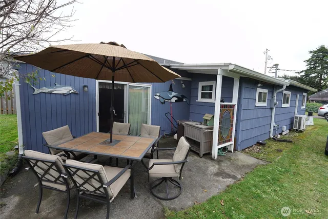 a backyard of a house with table and chairs