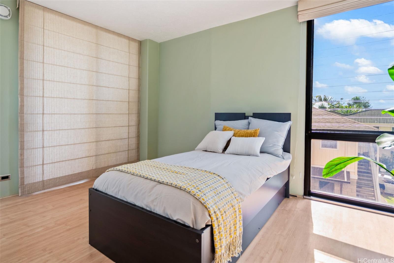 1505 Alexander Street, Unit 206 Honolulu, HI 96822 - Photo 9 of 20 a bedroom with a bed and a painting on the wall