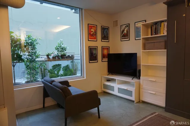 a living room with furniture tv and a window