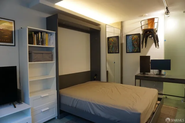 a bedroom with a bed and a flat screen tv