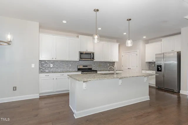 a kitchen with kitchen island a sink stainless steel appliances and cabinets