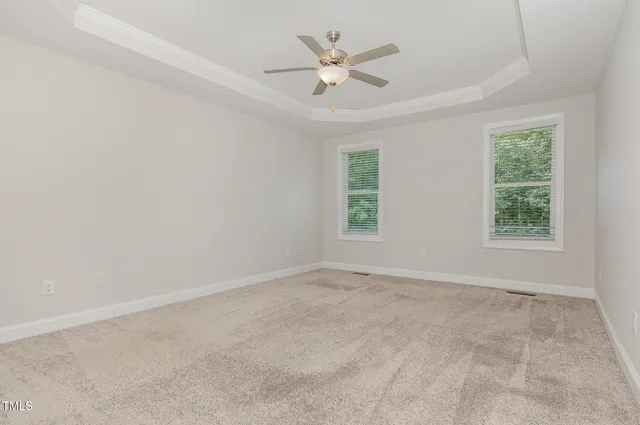 an empty room with a window and a ceiling fan