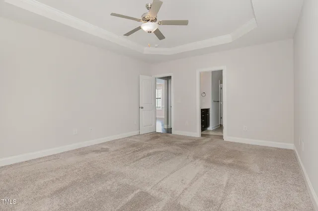 an empty room with closet and a ceiling fan