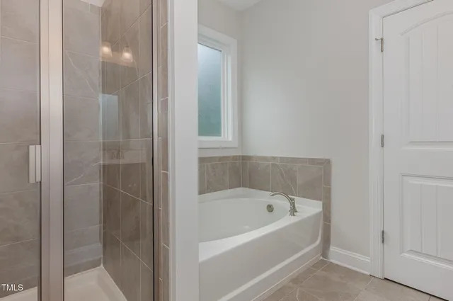 a white bath tub sitting next to a shower