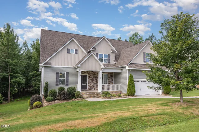 a front view of a house with a garden and yard