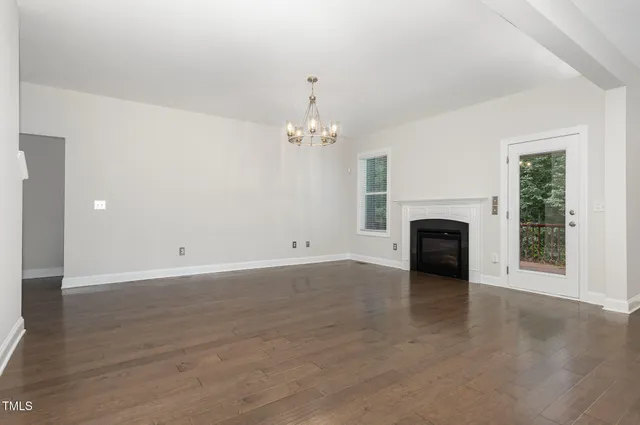 an empty room with fireplace and windows