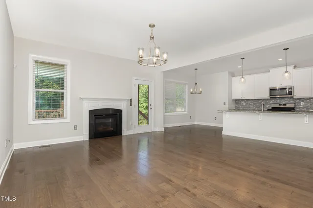 a view of a kitchen with granite countertop a fireplace and a window