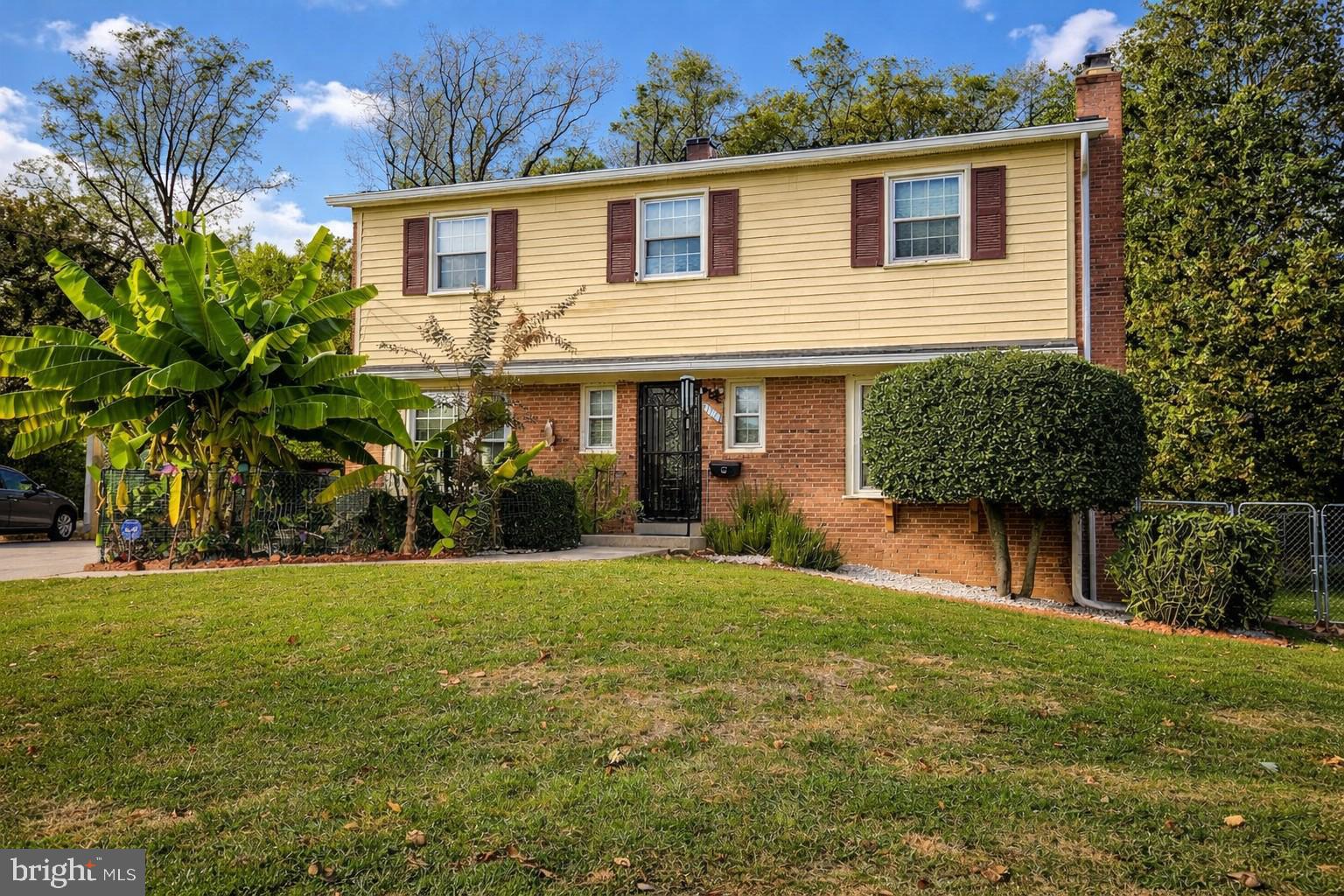 a front view of a house with a yard and potted plants
