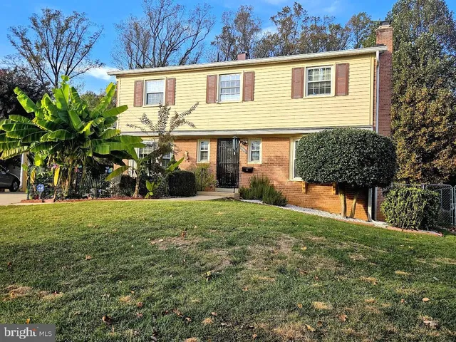 a view of a yard in front of a house with large trees
