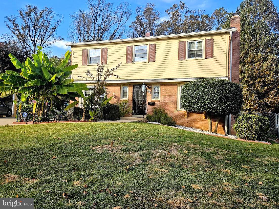 a view of a yard in front of a house with large trees