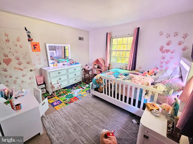 a bedroom with baby bed and a window