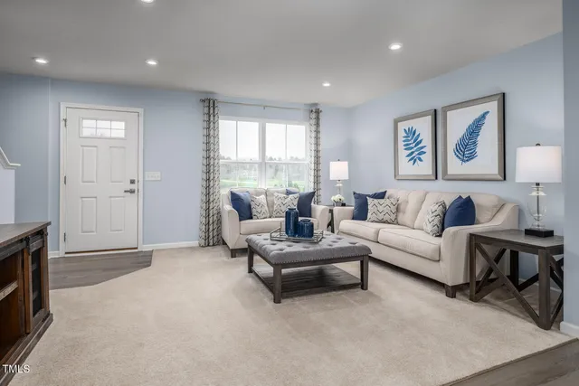 a living room with furniture a flat screen tv and a kitchen view