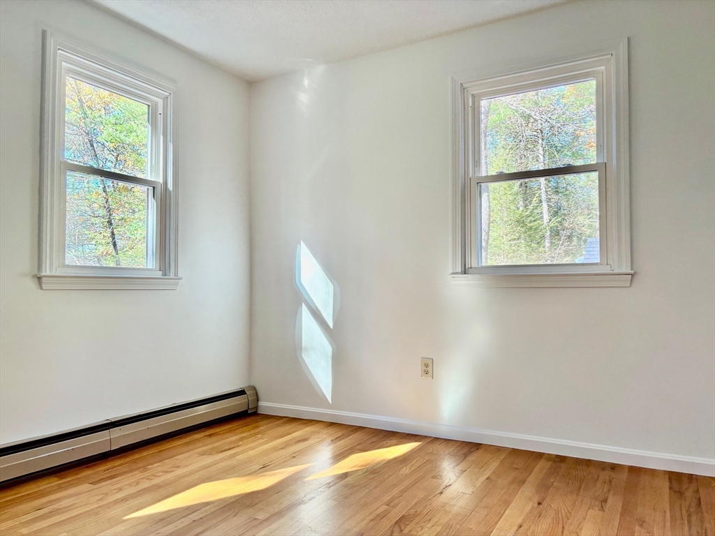 14 Pebble Ridge Road Amherst, MA 01002 - Photo 16 of 32 a view of an empty room with wooden floor and a window