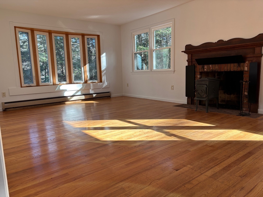 14 Pebble Ridge Road Amherst, MA 01002 - Photo 6 of 32 a view of empty room with wooden floor and a fireplace
