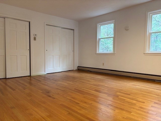 14 Pebble Ridge Road Amherst, MA 01002 - Photo 8 of 32 an empty room with wooden floor and windows