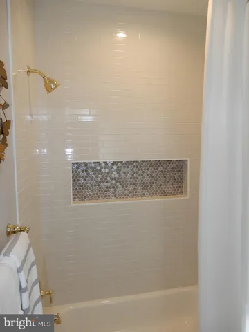 a white bath tub sitting in a bathroom next to a window