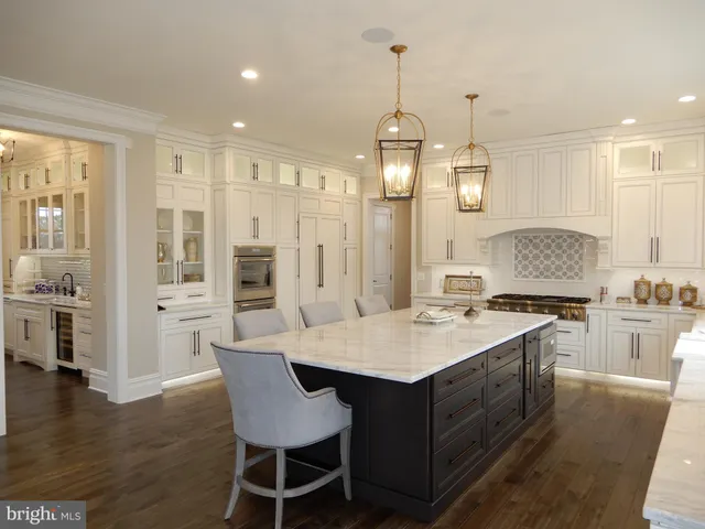 a view of kitchen with stainless steel appliances wooden floor and cabinets