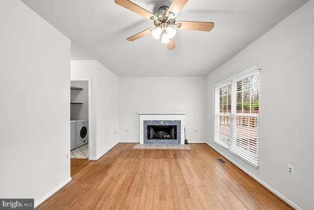 wooden floor fireplace and windows in an empty room