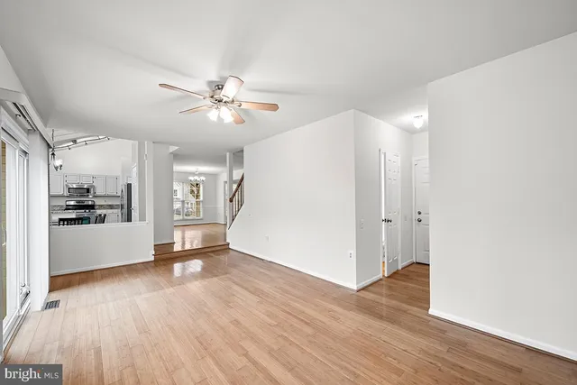 a view of a big room with wooden floor and a kitchen