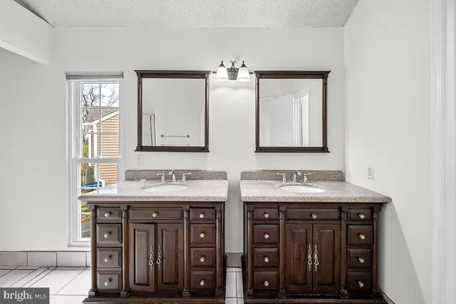 a bathroom with double sink and a mirror