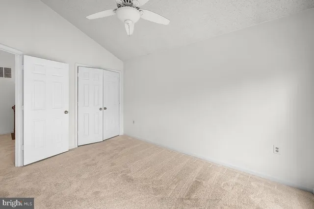 an empty room with a chandelier fan