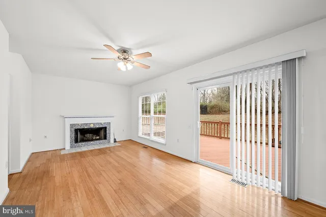 wooden floor fireplace and windows in an empty room