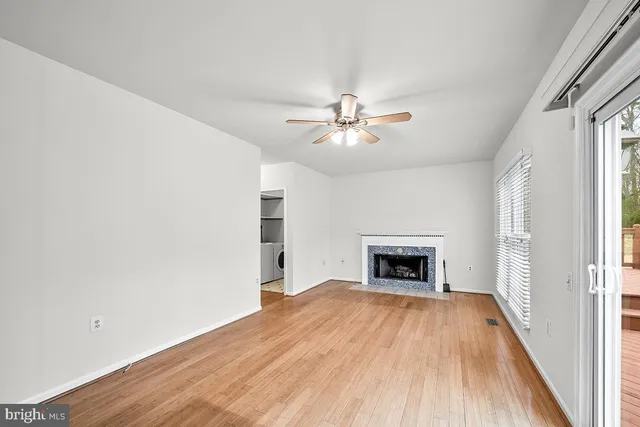 wooden floor fireplace and windows in an empty room
