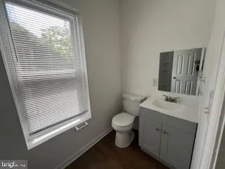 a bathroom with a sink toilet and window