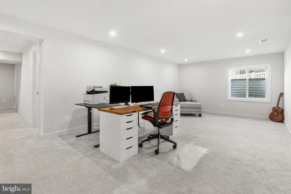 a view of a workspace with furniture and a window