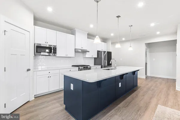 a kitchen with counter top space a sink appliances and cabinets