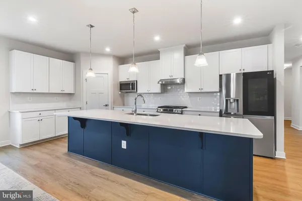 a kitchen with stainless steel appliances granite countertop a sink a stove and a wooden floors