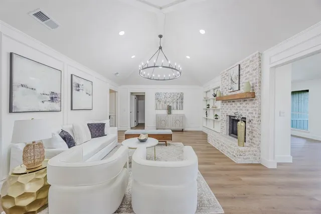 a living room with fireplace furniture and a chandelier