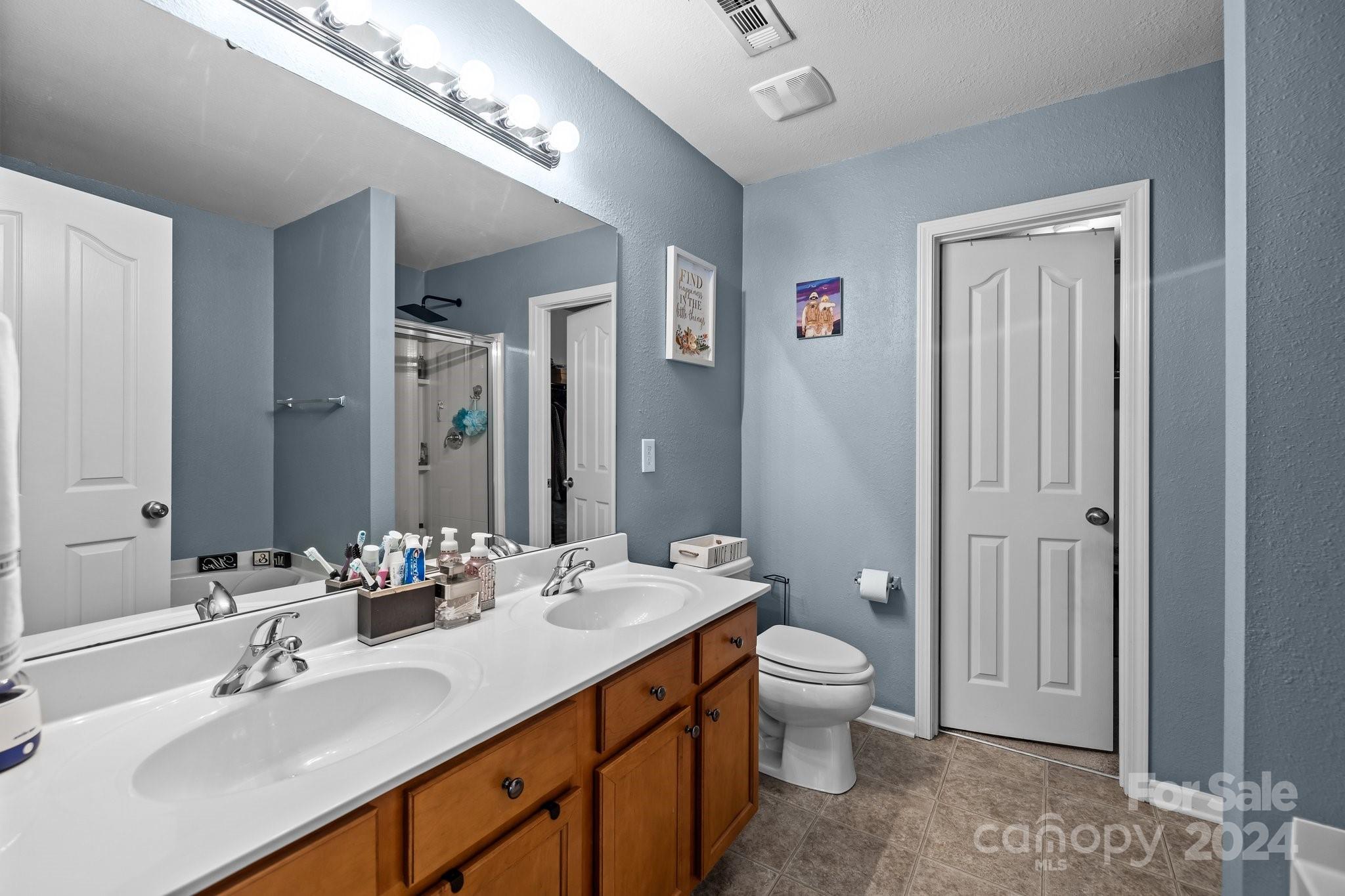 5511 Keener Ridge Road Charlotte, NC 28216 - Photo 12 of 31 a bathroom with a double vanity sink toilet and shower