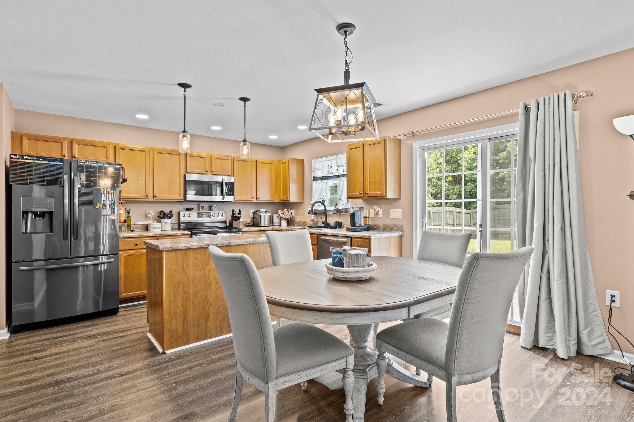 5511 Keener Ridge Road Charlotte, NC 28216 - Photo 22 of 31 a kitchen with stainless steel appliances granite countertop a dining table chairs refrigerator and cabinets