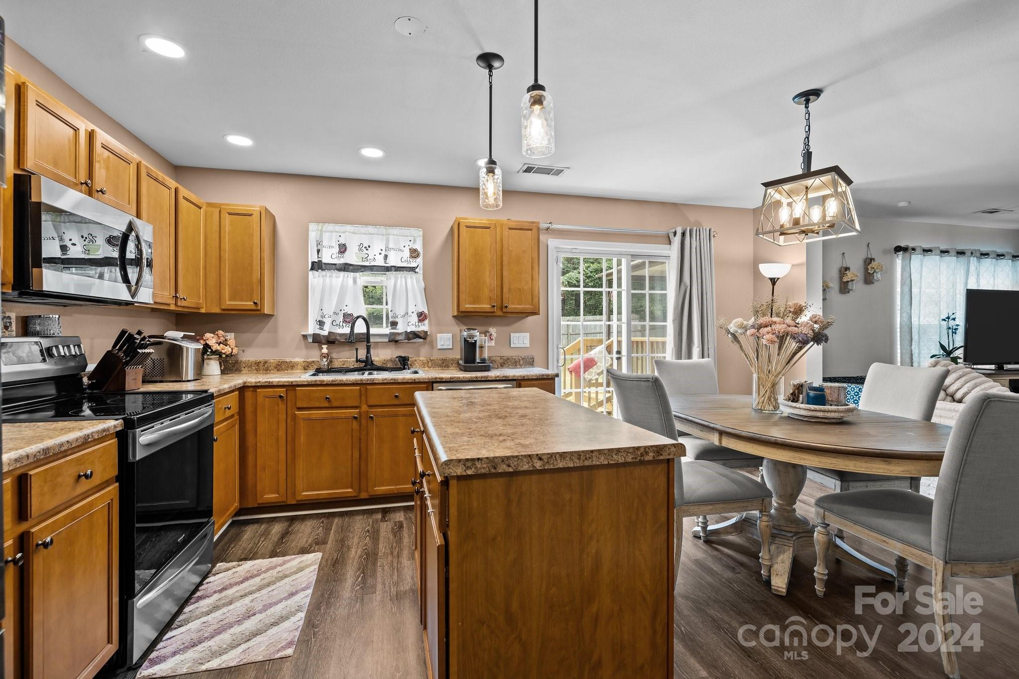 5511 Keener Ridge Road Charlotte, NC 28216 - Photo 24 of 31 a kitchen with stainless steel appliances granite countertop wooden cabinets a dining table and chairs