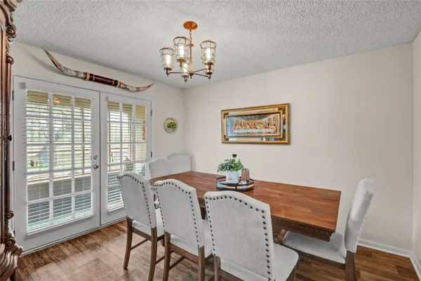 a view of a dining room with furniture a chandelier and wooden floor