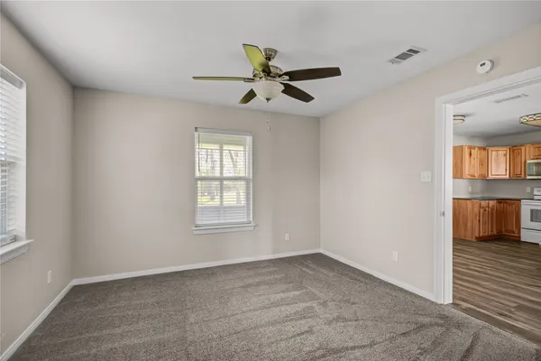 an empty room with closet and a ceiling fan