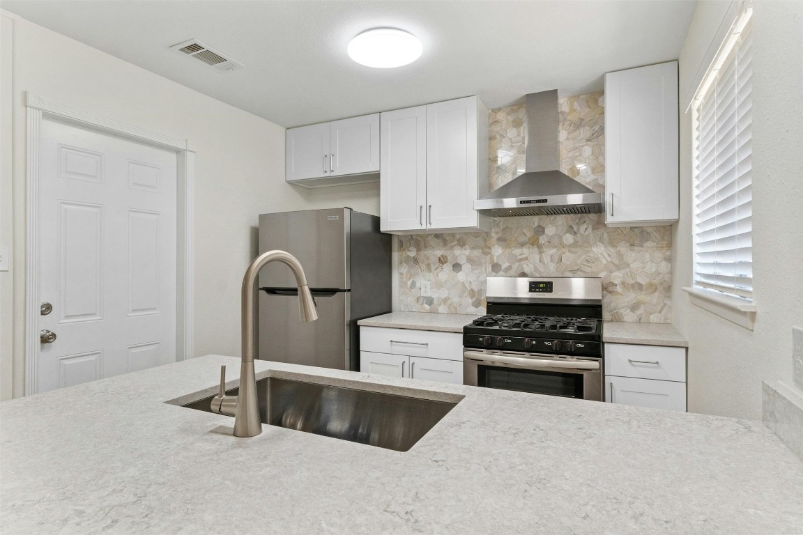 a kitchen with stainless steel appliances granite countertop a stove and a refrigerator