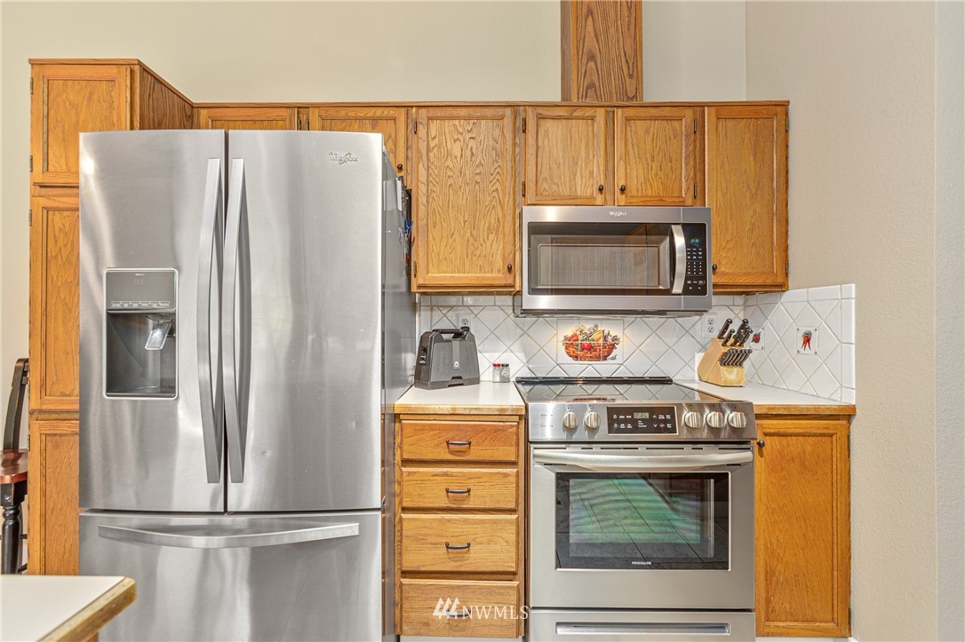 804 Duchess Road Bothell, WA 98012 - Photo 7 of 37 a kitchen with stainless steel appliances granite countertop a refrigerator a stove and a microwave