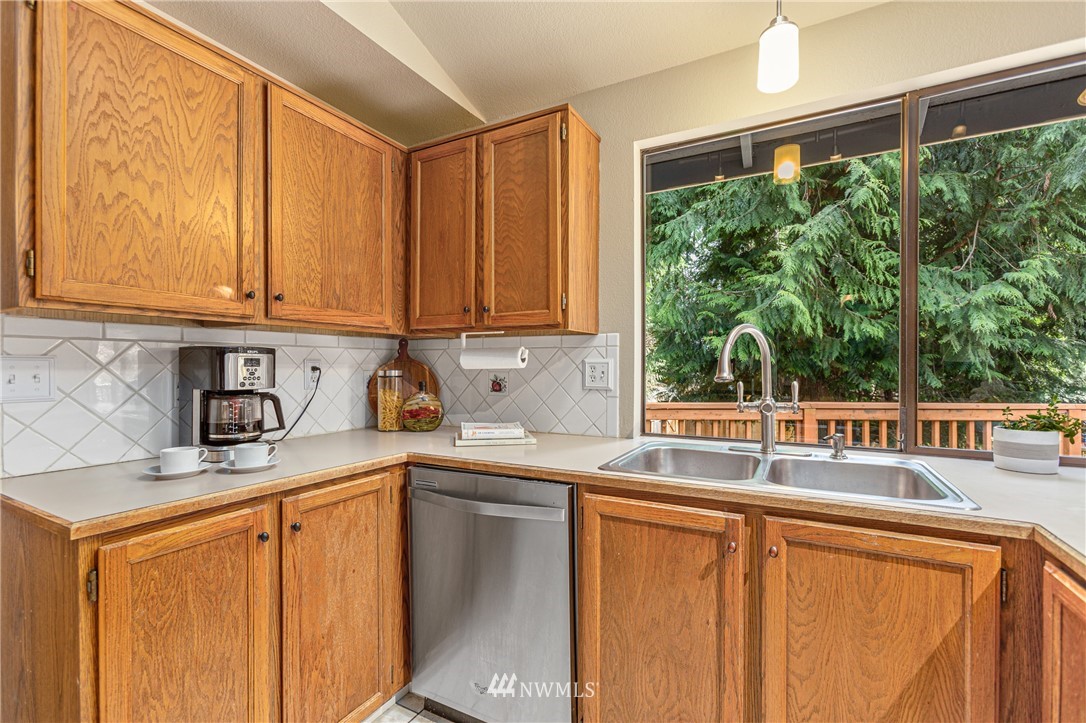 804 Duchess Road Bothell, WA 98012 - Photo 8 of 37 a kitchen with stainless steel appliances wooden cabinets a sink and a large window