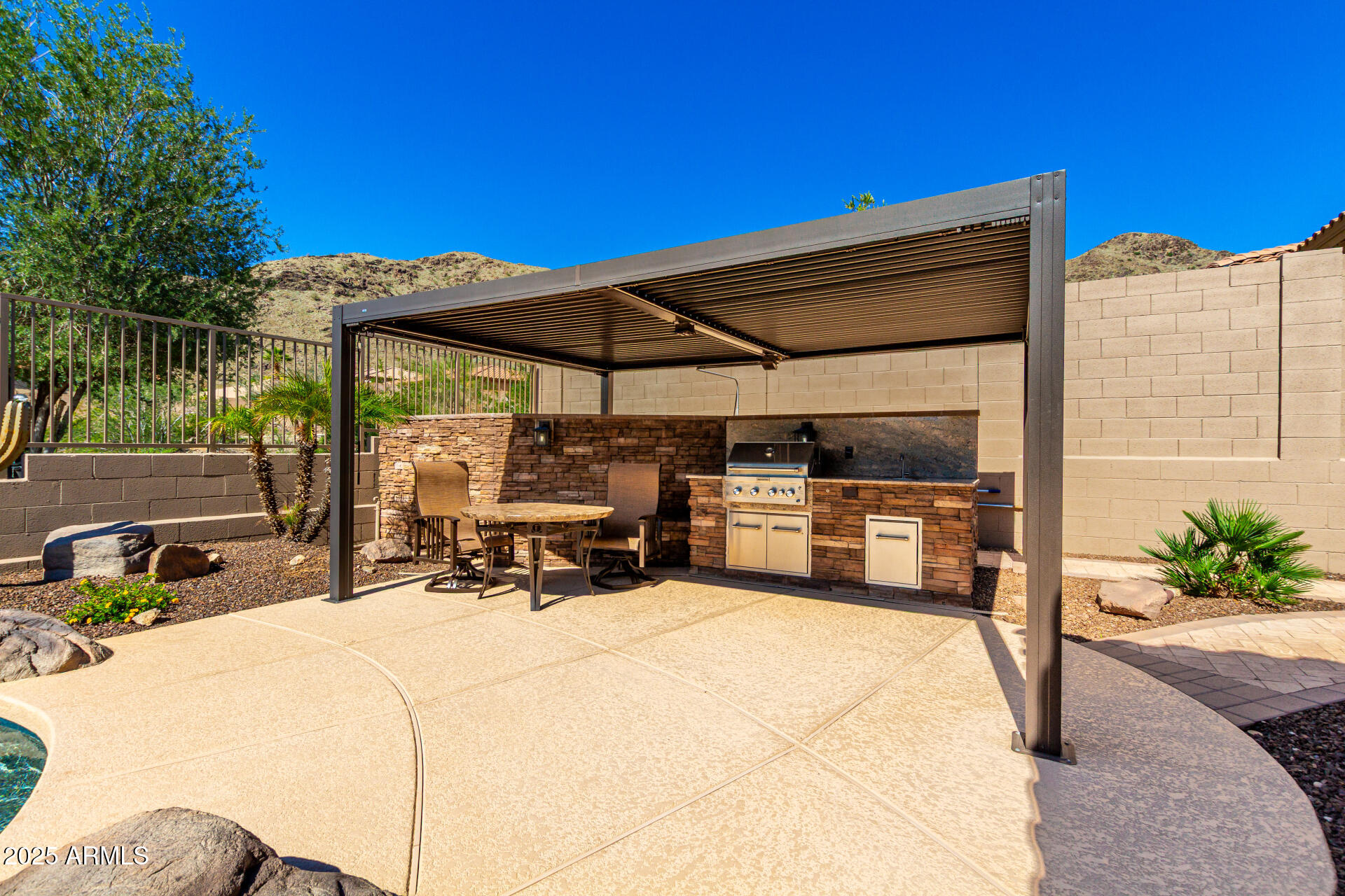 16030 South 27th Drive Phoenix, AZ 85045 - Photo 19 of 29 a view of a patio with table and chairs under an umbrella with wooden fence