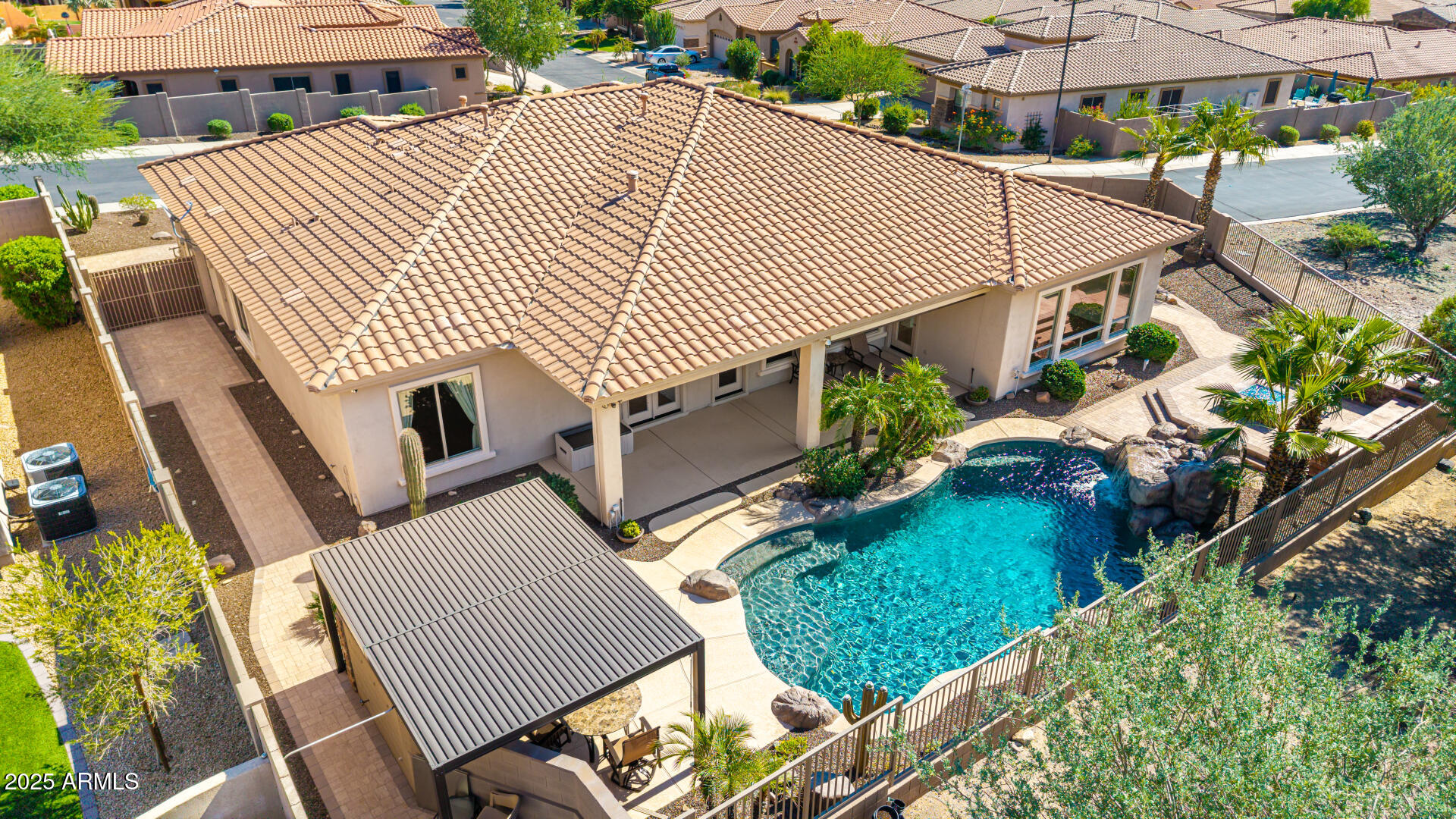 16030 South 27th Drive Phoenix, AZ 85045 - Photo 24 of 29 a view of a patio with table and chairs under an umbrella with a fire pit and potted plants