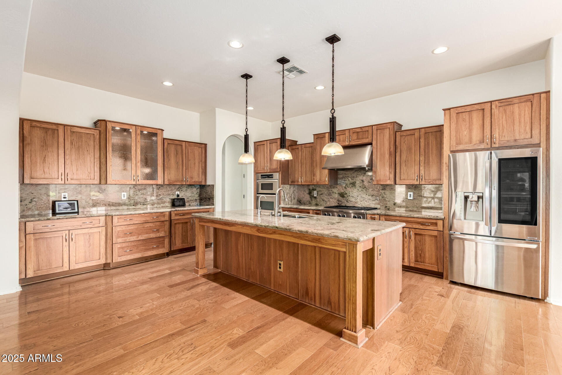 16030 South 27th Drive Phoenix, AZ 85045 - Photo 7 of 29 a large kitchen with stainless steel appliances granite countertop a stove a refrigerator a oven and a wooden floors