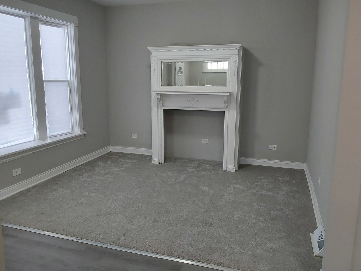 7712 South Evans Avenue Chicago, IL 60619 - Photo 3 of 22 a view of an empty room with a fireplace and a window