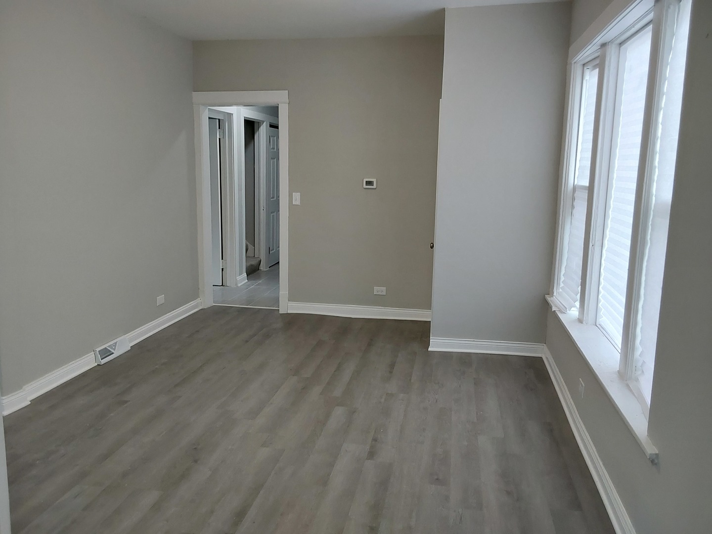 7712 South Evans Avenue Chicago, IL 60619 - Photo 4 of 22 a view of an empty room with wooden floor and a window