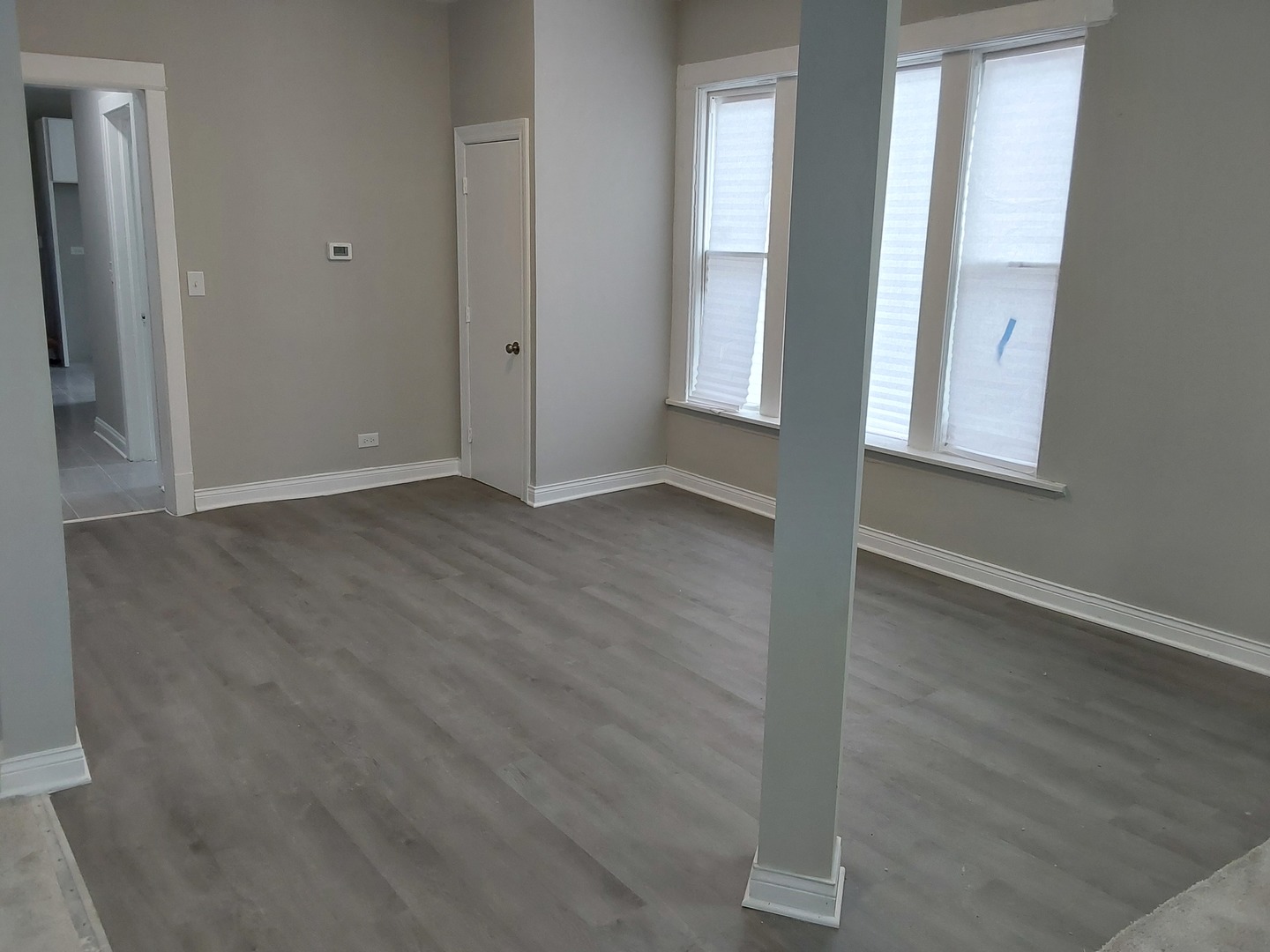 7712 South Evans Avenue Chicago, IL 60619 - Photo 5 of 22 an empty room with wooden floor and windows